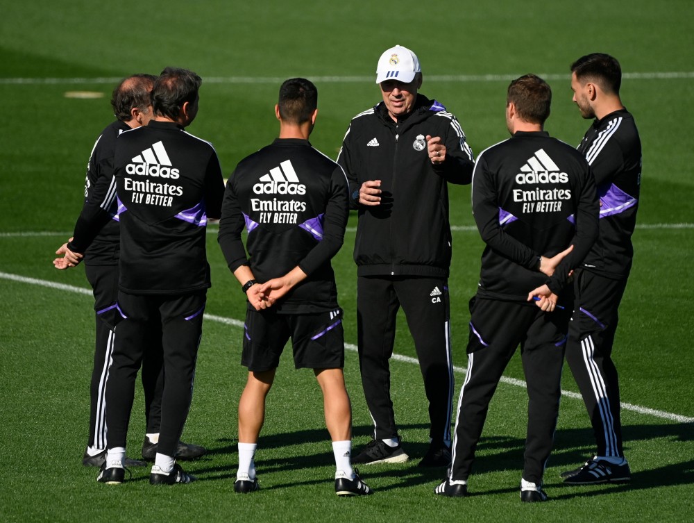Pelatih Real Madrid Italia Carlo Ancelotti (tengah) berbicara dengan stafnya selama sesi latihan sebelum pertandinganLiga Spanyol melawan FC Barcelona. AFP